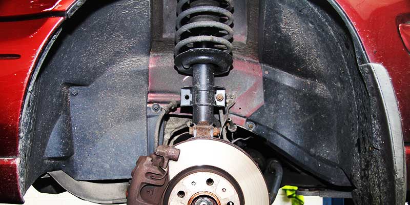 close up underneath a vauxhall showing leaking shock absorbers