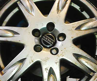 a very diry old volvo wheel close up