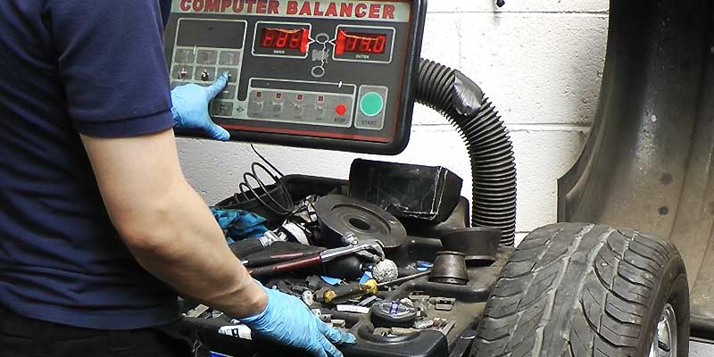 a mechanic balancing a car wheel on excels specialist wheel balancing machine