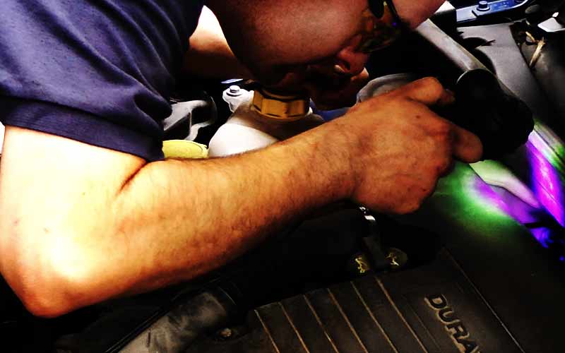 excel air con expert maticulously examining a volkswagen car air conditioning system for faults using uv light to highlight the fluorescent injected dye