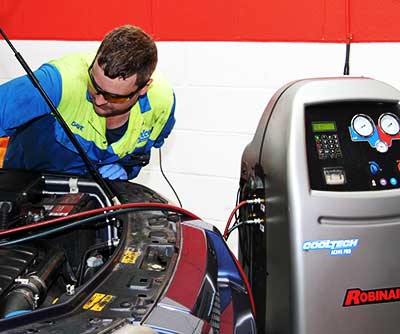 air conditioning expert repairing and regassing a car air con system