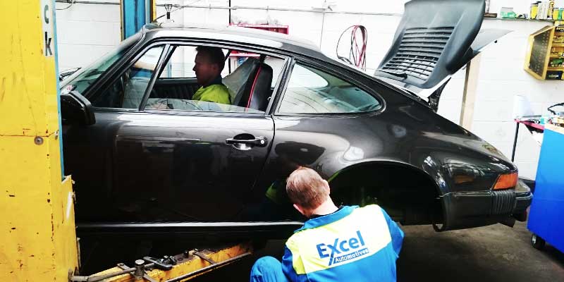 close up of a porsche car brake shoes being repaired by replacing the pads and disks and regreasing