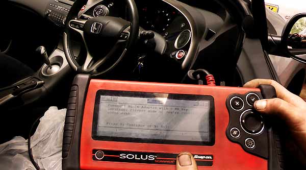 close up of computer fault finding diagnosis equipment with screen showing the device connecting to the vehicles on board computer to diagnose any faults