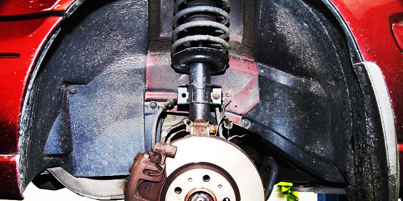 close up underneath a vauxhall showing leaking shock absorbers