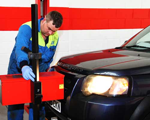 a blue land rover geting its lights checked by an excel mechanic