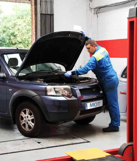 close up of a mechanic lifting a vehicle bonnet to perform repairs inside excels newlt refurbished garage