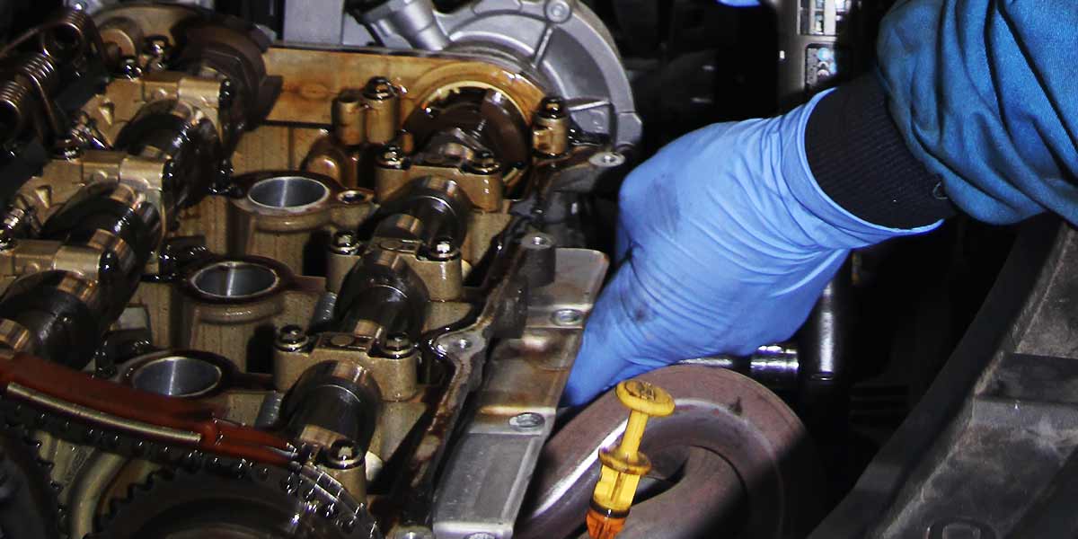 mechanic removing a car cyclinder head which needs skimming and repairing
