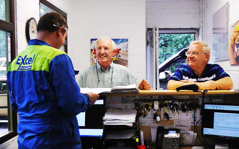 excel reception area with two customers being served by two excel mechanics