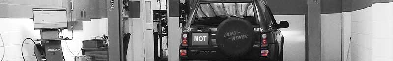 very classy black and white expert photo of excels mot testing bay with a land rover part way through testing