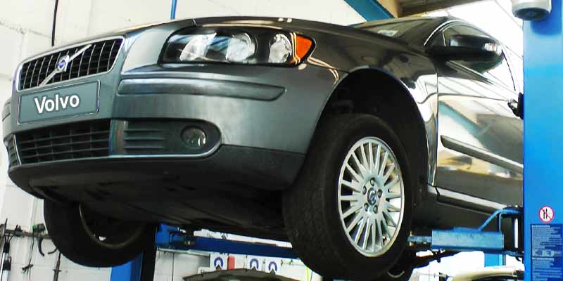 older volvo d5 high in the air on a ramp with a mechanic inspecing for potential and existing issues