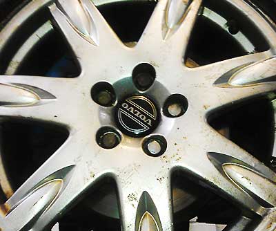 a very diry old volvo wheel close up