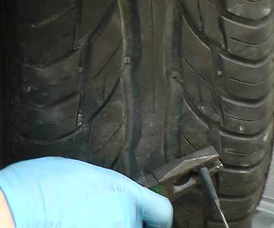 tyre with a puncture plug patch being held in place by the repairer