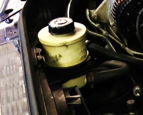 close up of a fords steering fluid reservoir at correct fill level