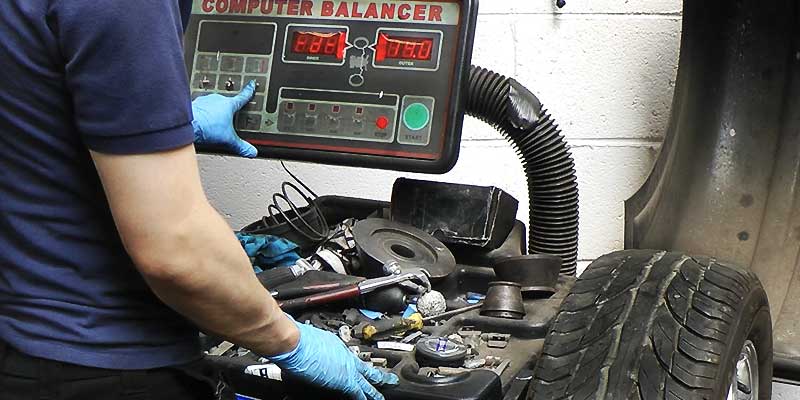 a mechanic balancing a car wheel on excels specialist wheel balancing machine